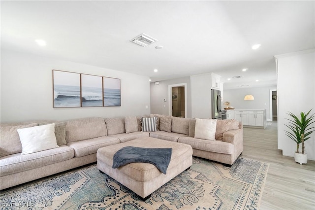 living room with light wood finished floors and recessed lighting