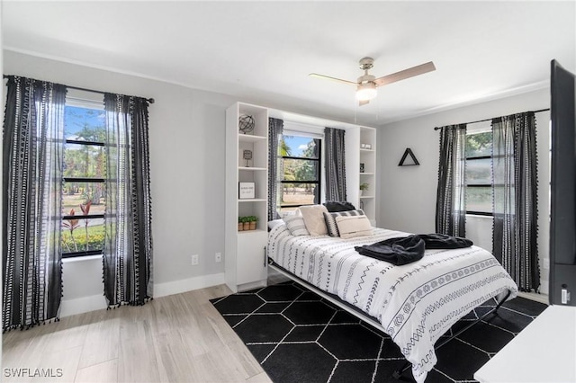 bedroom featuring multiple windows, ceiling fan, and wood finished floors
