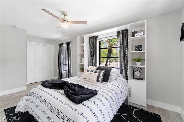 bedroom with a closet, baseboards, and light wood finished floors