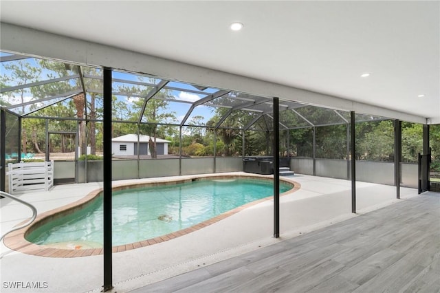 swimming pool featuring a jacuzzi, a patio area, and a lanai