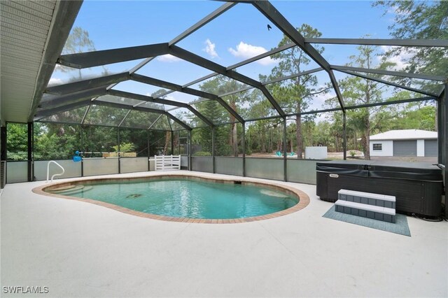 swimming pool featuring a hot tub and a patio area
