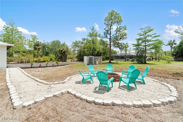 view of grassy yard featuring an outdoor fire pit