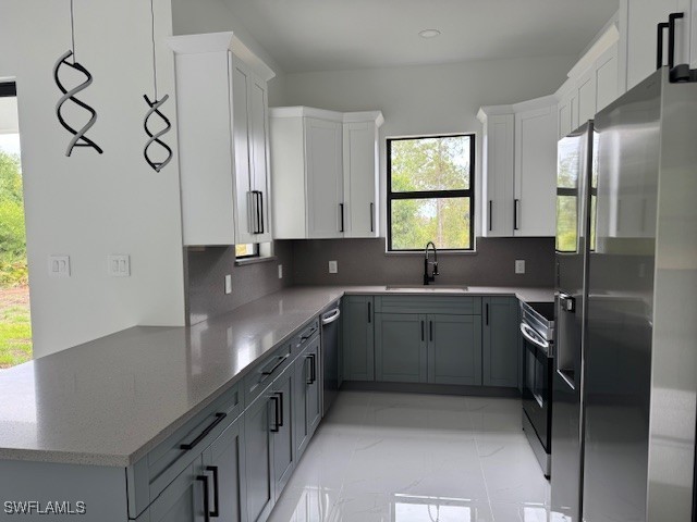 kitchen featuring white cabinetry, stainless steel appliances, decorative backsplash, and a sink