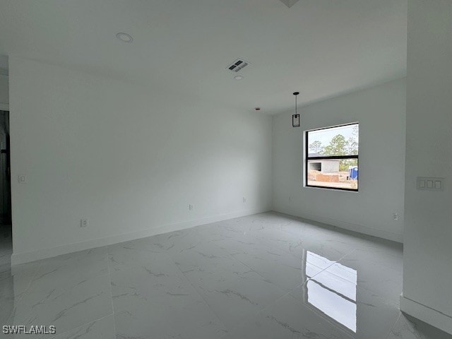 empty room with baseboards, marble finish floor, and visible vents