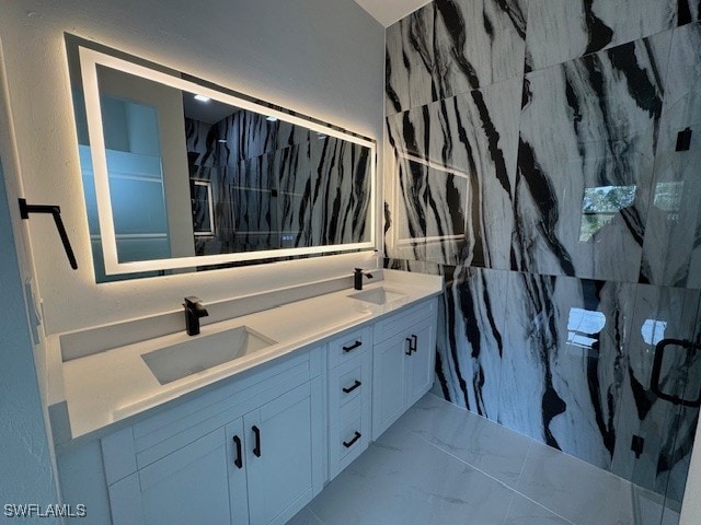 bathroom with a sink, double vanity, marble finish floor, and a shower