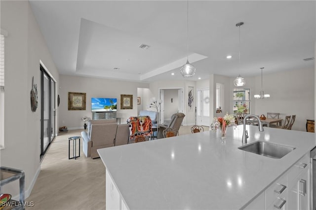 kitchen with white cabinetry, light countertops, visible vents, and a sink