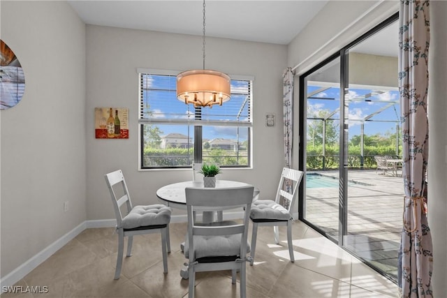 dining room featuring a notable chandelier, baseboards, and light tile patterned floors