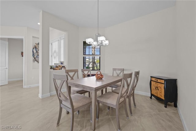 dining space with light tile patterned flooring, a notable chandelier, and baseboards
