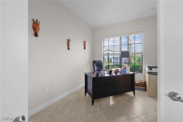 office featuring vaulted ceiling, baseboards, and light tile patterned floors