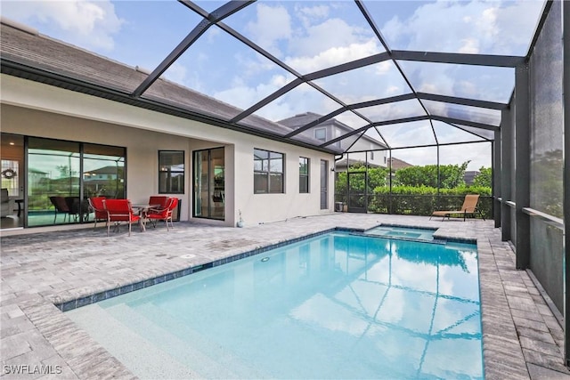 view of swimming pool featuring a patio, a pool with connected hot tub, and a lanai