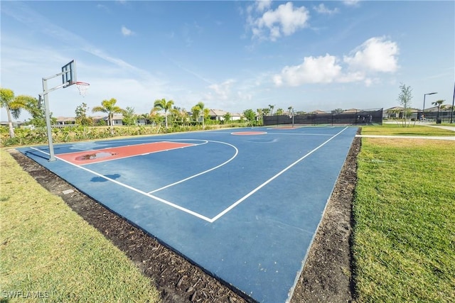 view of sport court featuring a yard, fence, and community basketball court