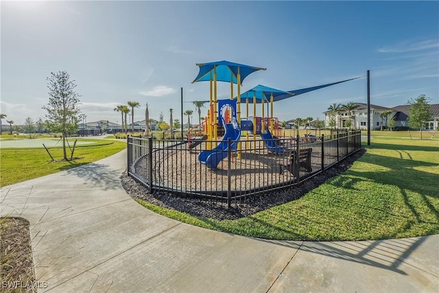 communal playground with a yard, fence, and a residential view