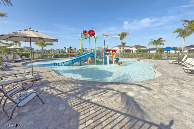 community play area with a patio area, a water play area, fence, and a community pool