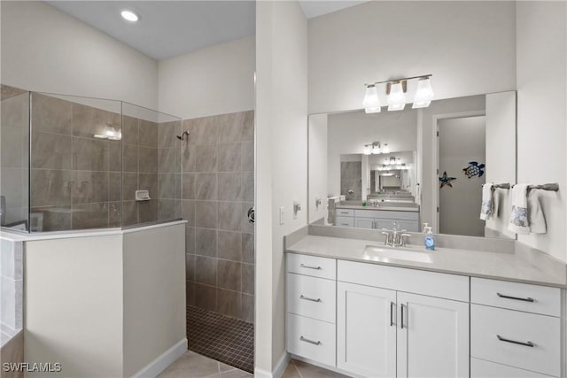 bathroom featuring walk in shower, tile patterned flooring, and vanity