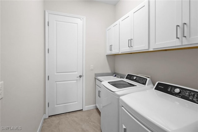 laundry area featuring washing machine and clothes dryer, baseboards, a sink, and cabinet space