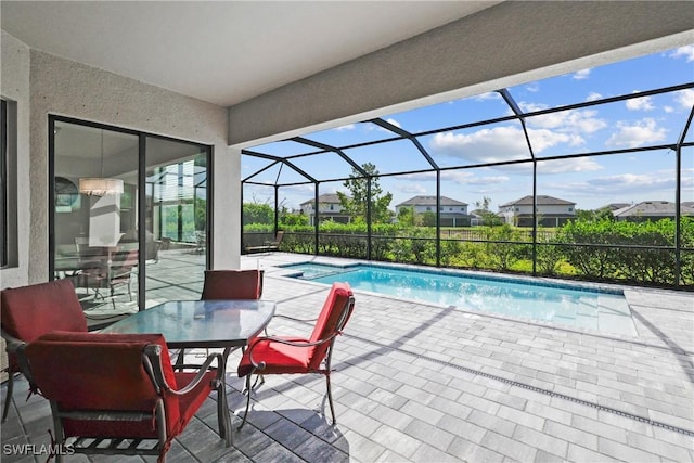 view of pool with a patio area, a pool with connected hot tub, and a lanai