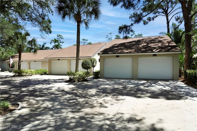 15400 Cedarwood Ln Unit 204, Naples, FL 34110 - mid-century inspired home with stucco siding, an attached garage, and roof with shingles