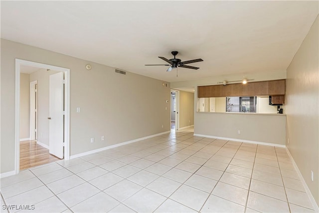 empty room with ceiling fan, baseboards, light tile patterned floors, and visible vents