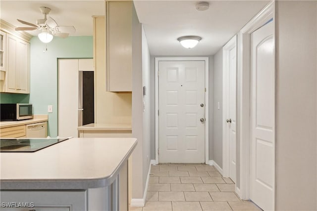 kitchen featuring light tile patterned floors, stainless steel microwave, baseboards, ceiling fan, and white dishwasher