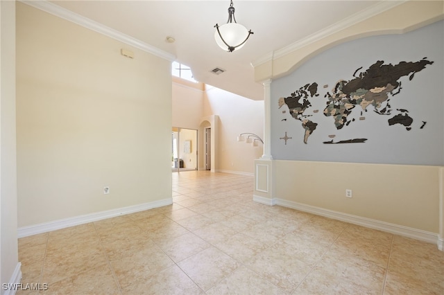 spare room with arched walkways, crown molding, ornate columns, and tile patterned floors