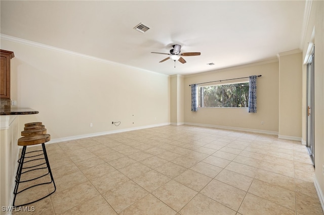 empty room featuring ceiling fan, ornamental molding, light tile patterned flooring, and baseboards