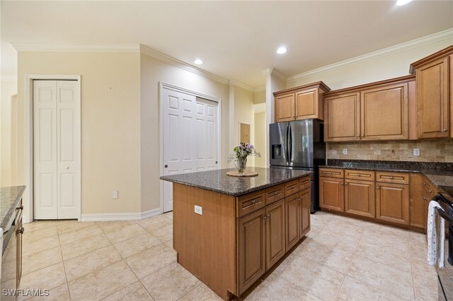 kitchen with stainless steel refrigerator with ice dispenser, brown cabinetry, decorative backsplash, ornamental molding, and recessed lighting