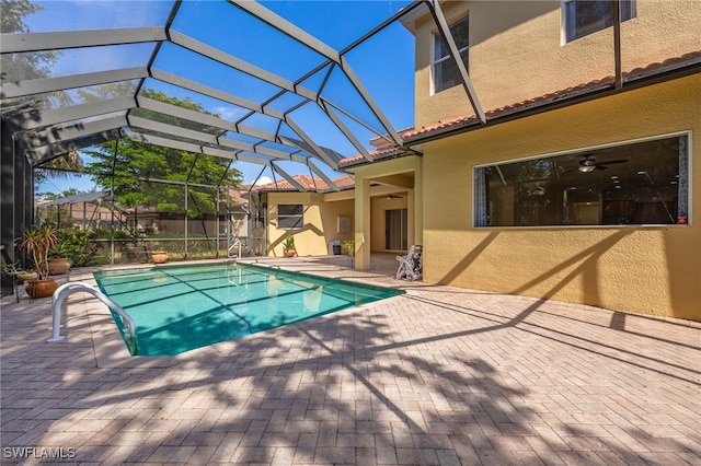view of swimming pool with a patio, a lanai, and a ceiling fan