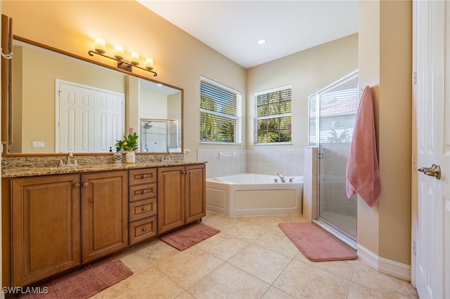 bathroom with a shower stall, a garden tub, double vanity, and tile patterned floors