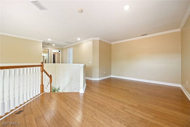spare room featuring recessed lighting, baseboards, wood finished floors, and ornamental molding