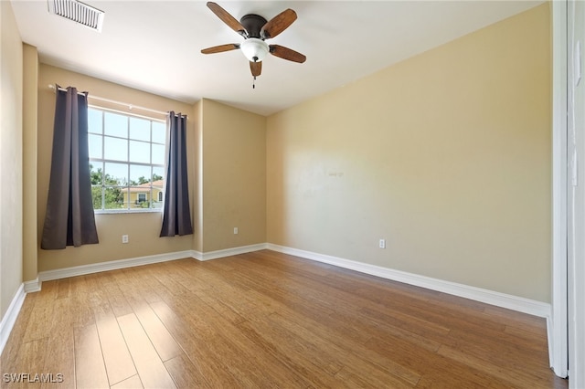 empty room with wood finished floors, ceiling fan, and baseboards