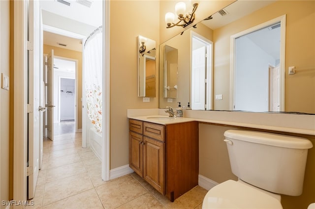 bathroom with a chandelier, toilet, baseboards, tile patterned flooring, and vanity