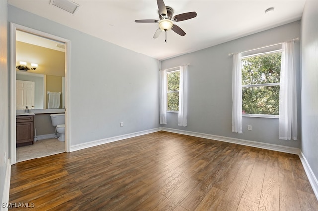 empty room featuring a ceiling fan, hardwood / wood-style flooring, and baseboards