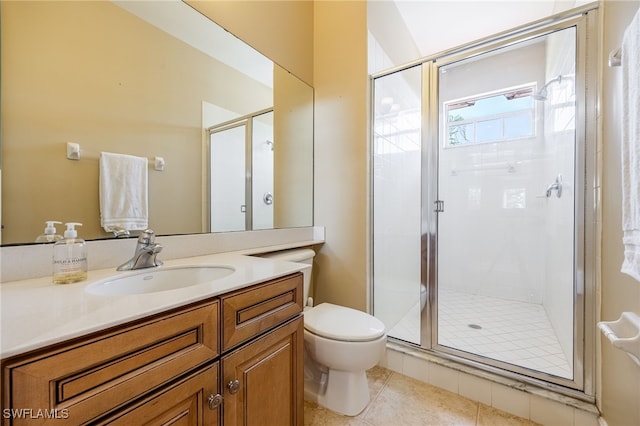 bathroom with a stall shower, toilet, vanity, and tile patterned floors