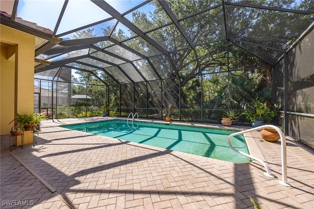 swimming pool featuring a patio and glass enclosure