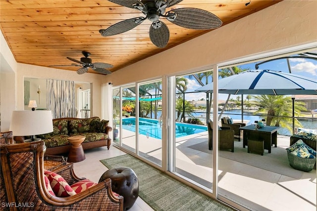 sunroom featuring ceiling fan, an outdoor hangout area, a pool, and lofted ceiling
