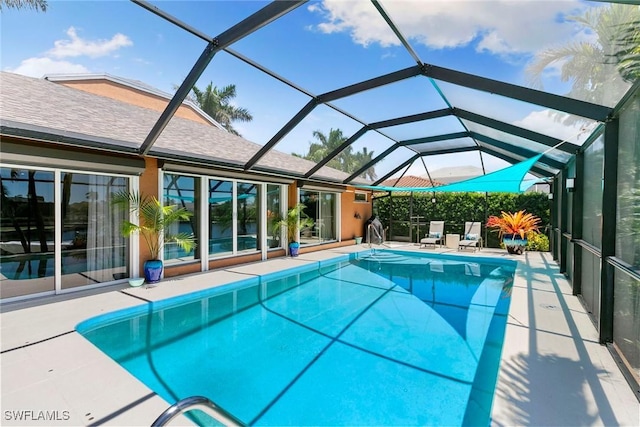 outdoor pool featuring a patio and glass enclosure