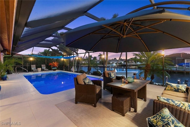outdoor pool with an outdoor hangout area, a water view, a patio area, and glass enclosure