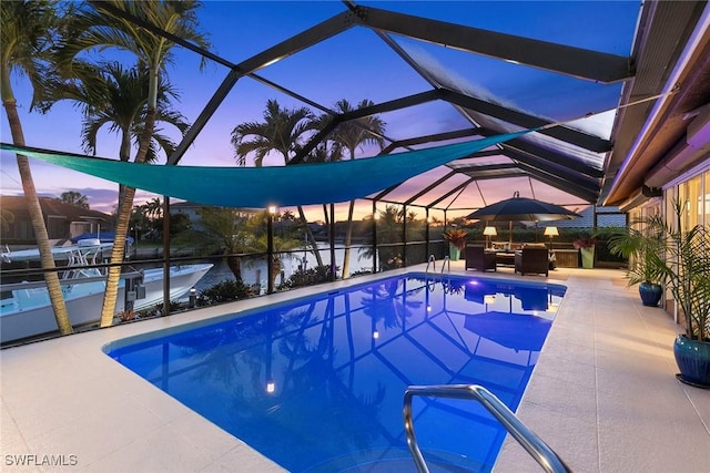 swimming pool with a patio area and glass enclosure
