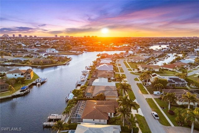 aerial view at dusk of a water view and a residential view