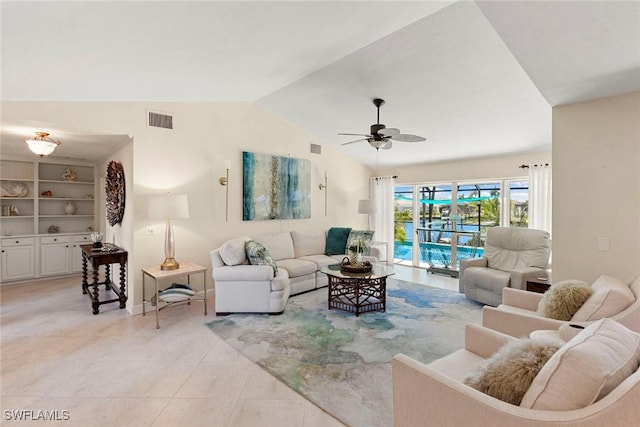 living area with light tile patterned floors, vaulted ceiling, ceiling fan, and baseboards