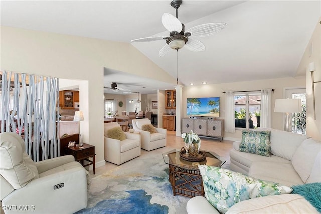 living room featuring ceiling fan, vaulted ceiling, and baseboards