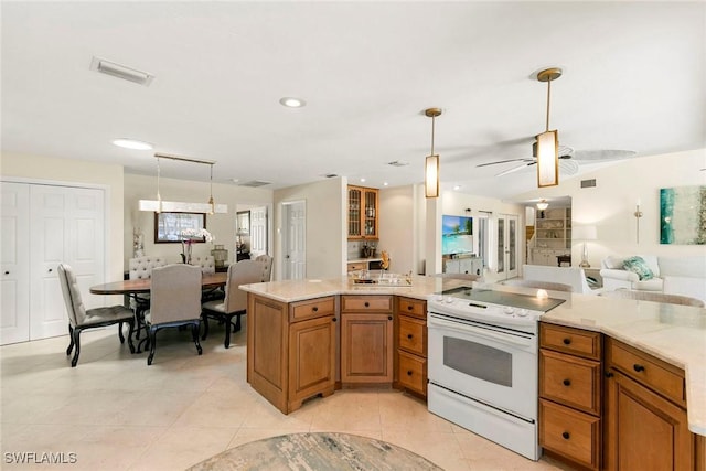 kitchen featuring white electric stove, open floor plan, hanging light fixtures, brown cabinets, and recessed lighting