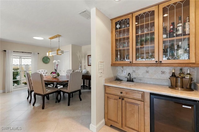 indoor bar featuring wine cooler, backsplash, decorative light fixtures, baseboards, and light tile patterned floors