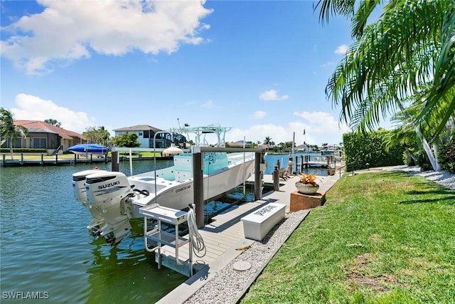 dock area featuring boat lift, a water view, and a lawn
