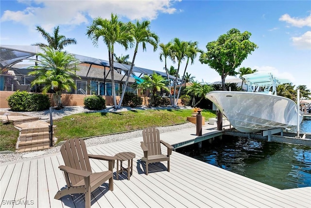 dock with boat lift, a water view, a lanai, and a yard