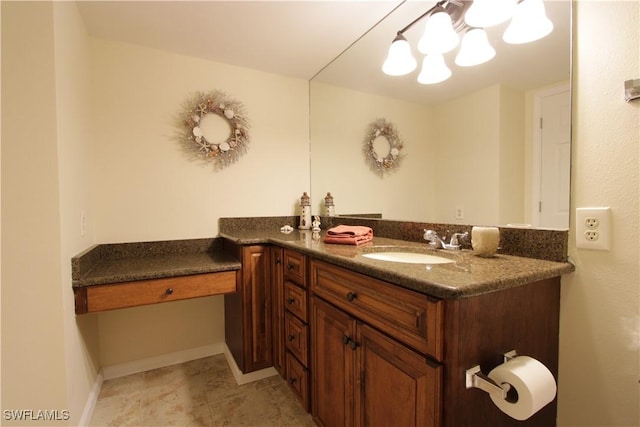 bathroom with a chandelier, vanity, and baseboards