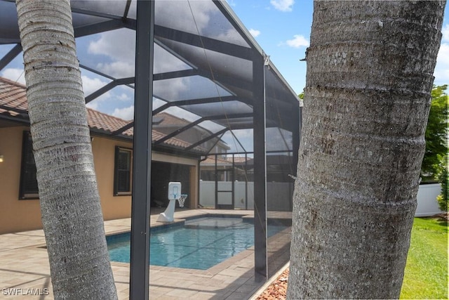 view of swimming pool featuring a lanai and a patio area
