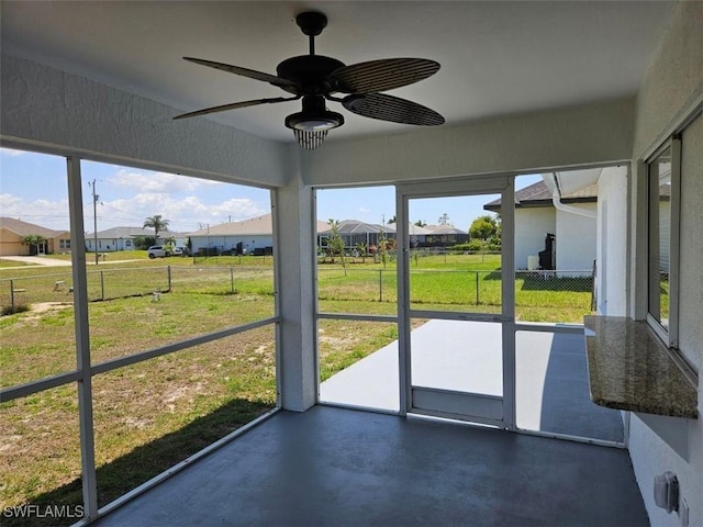 417 NW 18th Pl, Cape Coral, FL 33993 - unfurnished sunroom featuring a ceiling fan, a healthy amount of sunlight, and a residential view