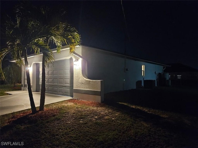 417 NW 18th Pl, Cape Coral, FL 33993 - property exterior at twilight featuring stucco siding, driveway, and a garage