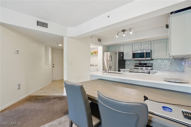 4109 Residence Dr Unit 515, Fort Myers, FL 33901 - kitchen with appliances with stainless steel finishes, light countertops, backsplash, and light colored carpet